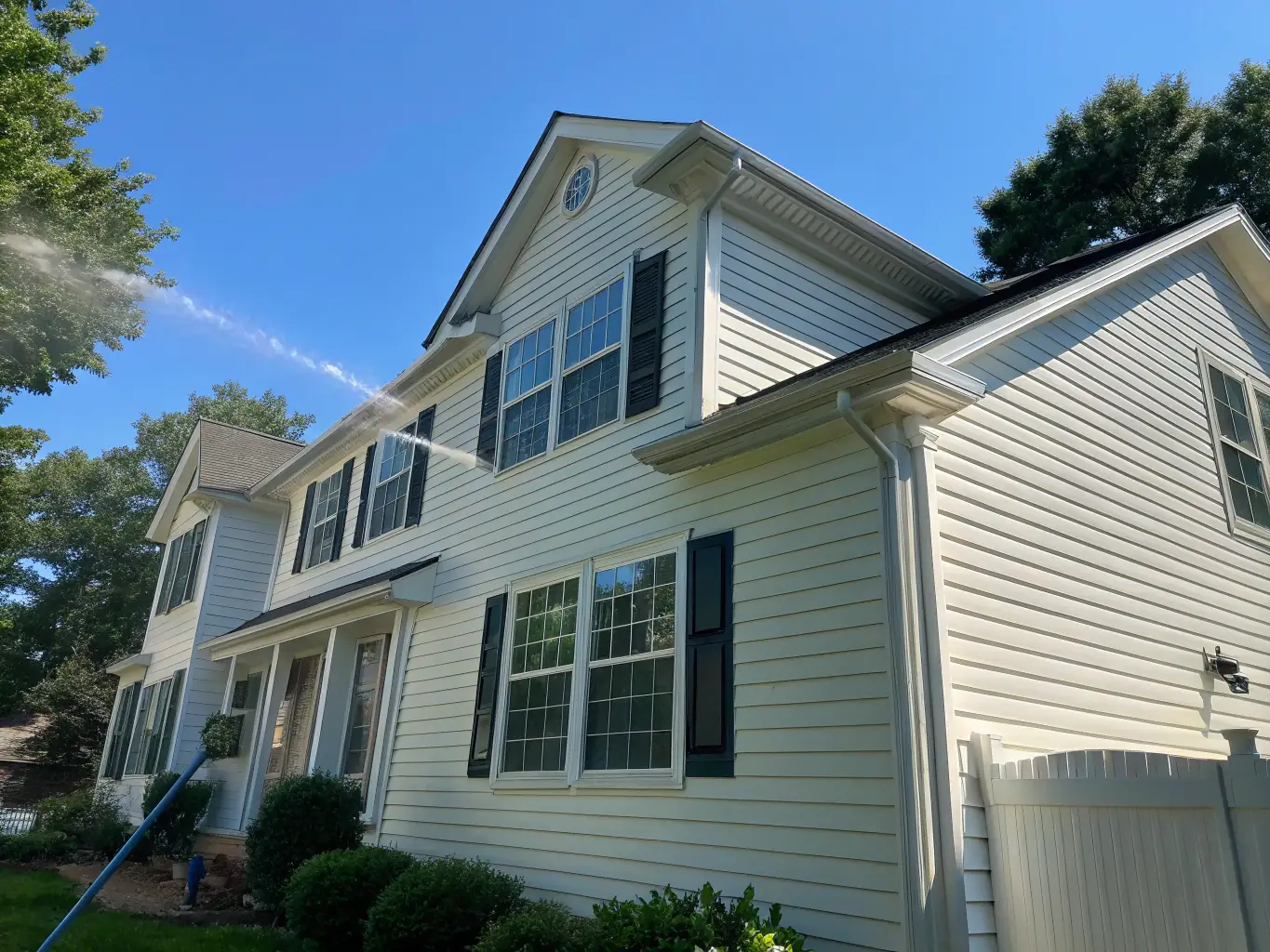A residential house with clean siding after power washing, showcasing the effectiveness of Optimized Pressure Washing LLC's residential services.